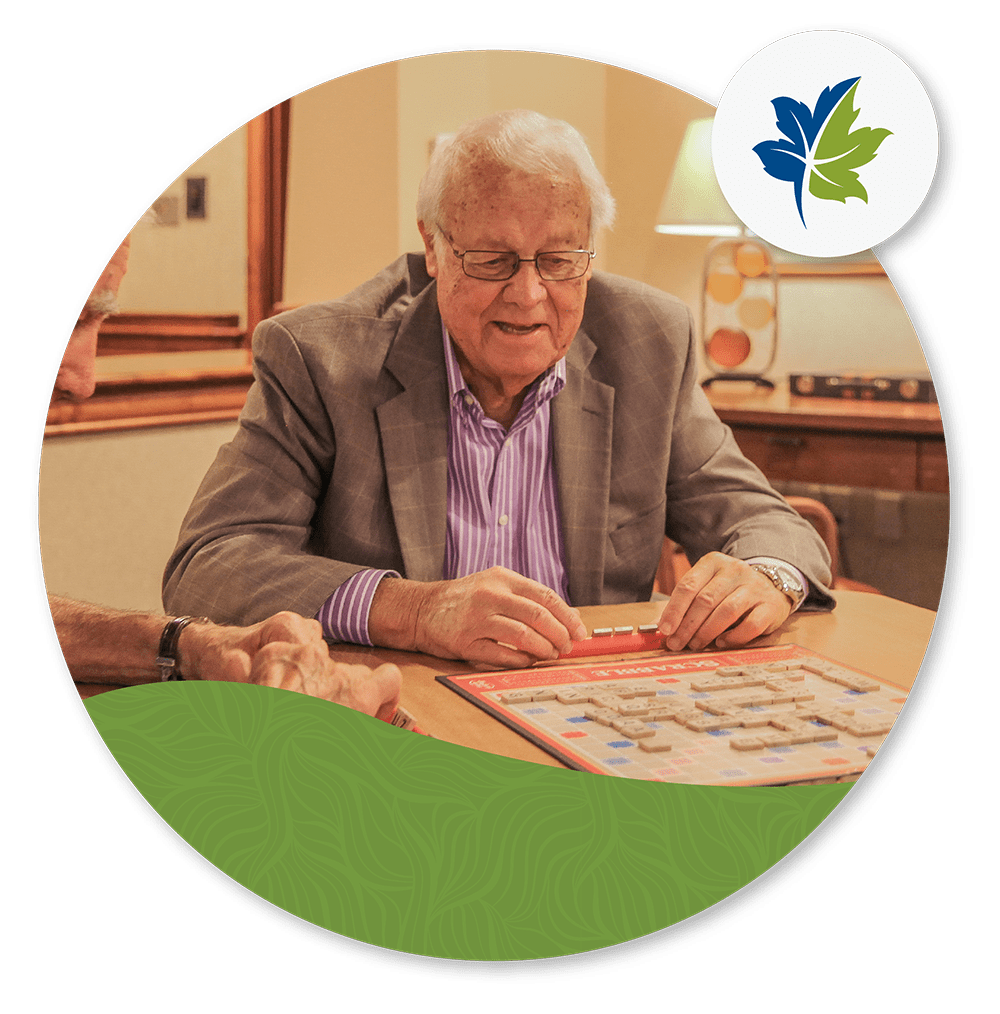 older-man-sittign-at-table older man sitting at table playing scrabble